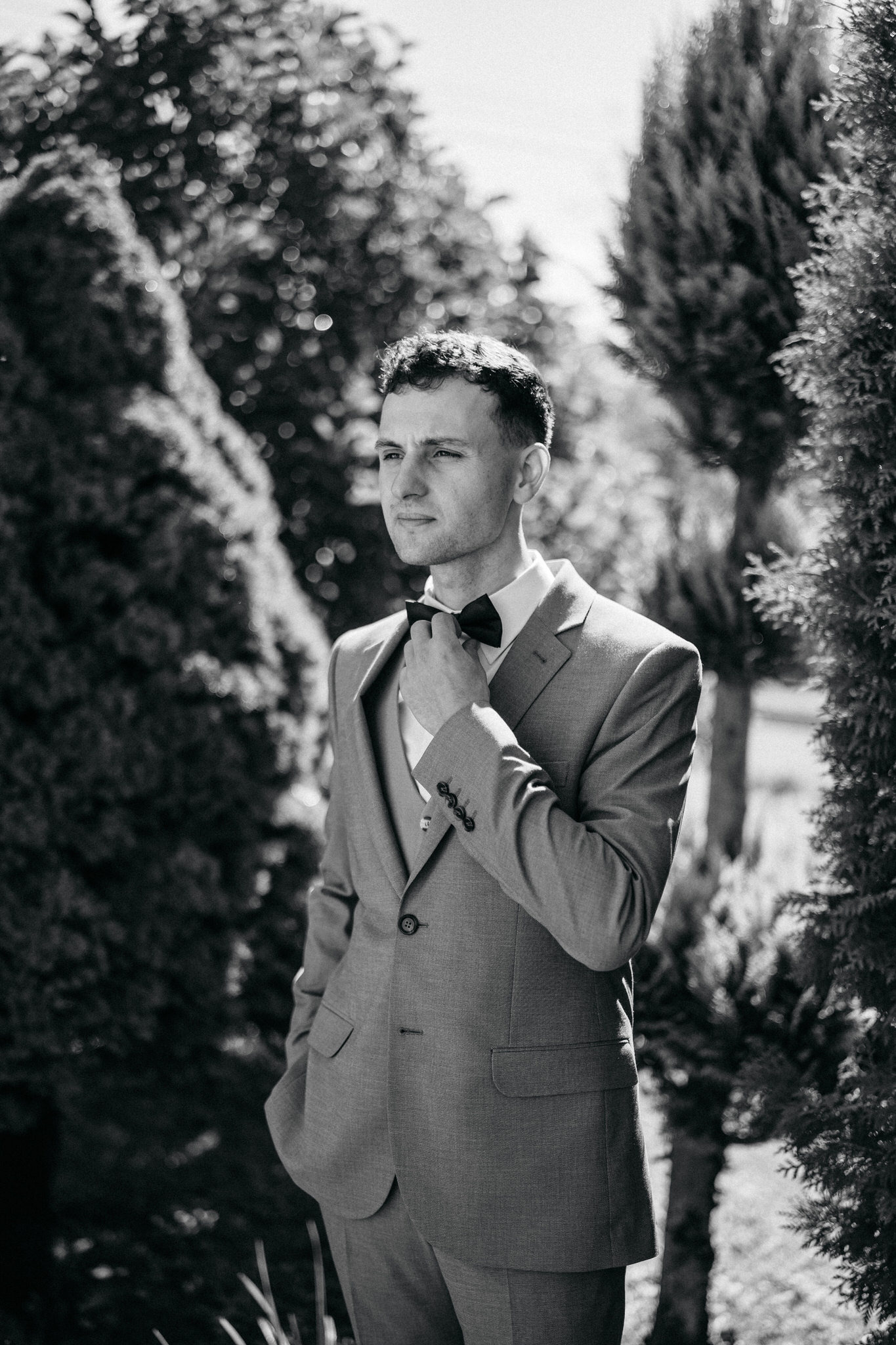 Wesele Zamek Dubiecko – pan młody poprawia muszkę, czarno-biała fotografia